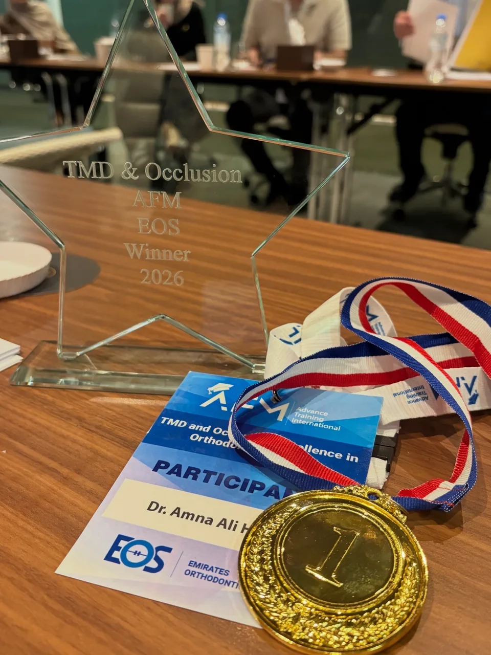 The TMD and Occlusion winner trophy and gold medal, with Dr Amna's participant badge