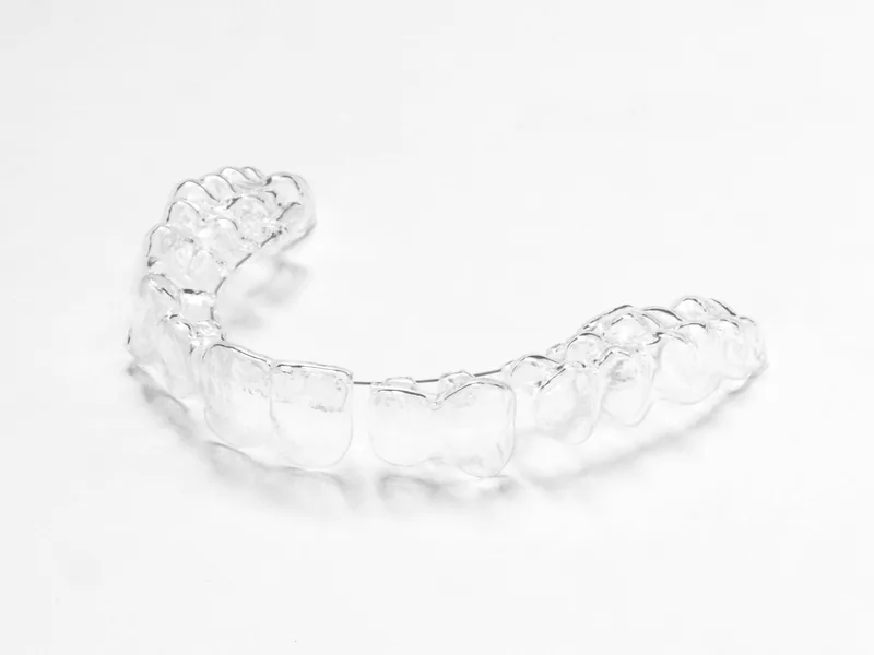 A clear aligner on a white surface