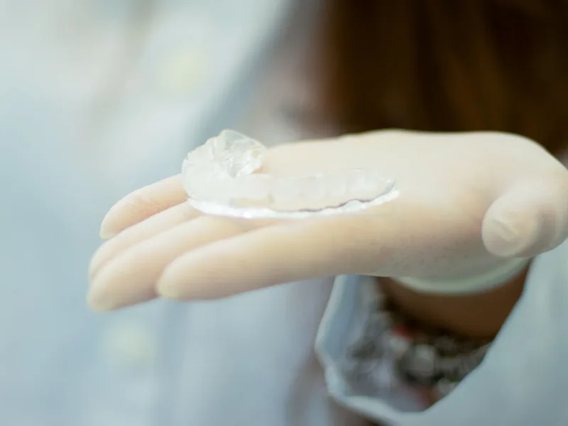 A clear, hard splint held in a gloved hand
